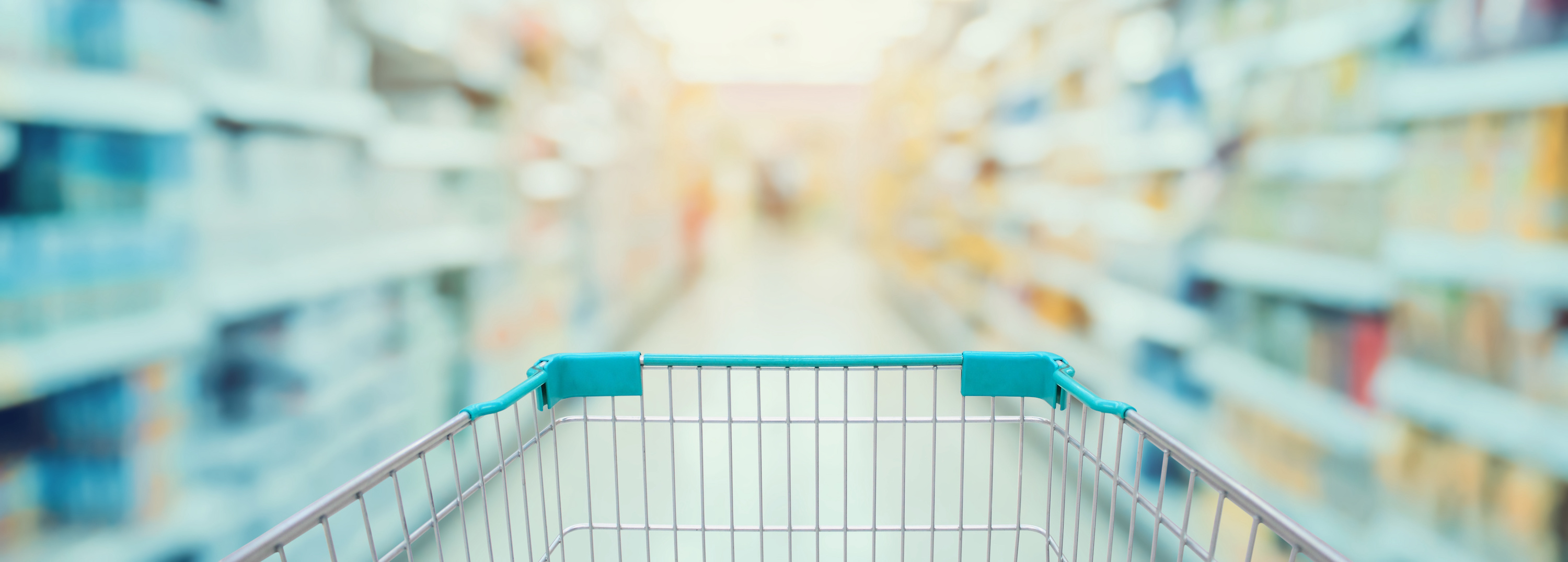 grocery cart moving down a blurred out grocery store aisle 