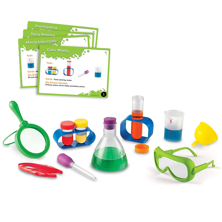 Primary Science Lab Kit contents. Top right shows a set of activity cards. Below shows a magnifying glass, tweezers, baster, 2 short test tubes in a stand, eyedropper, tall test tube in a stand, measuring cup, funnel, and safety goggles.
