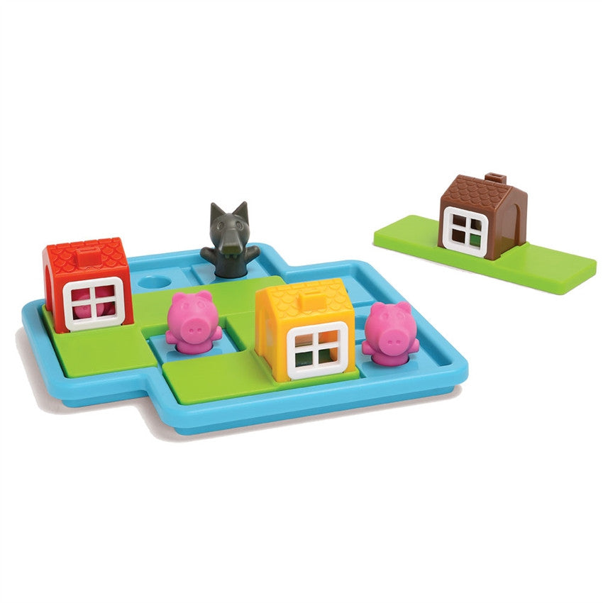 Three Little Piggies game. The game board is light blue with playing pieces on the board, including; a red house, a yellow house, 3 pigs, and a wolf. Off to the left side is a brown house piece. The game is played by placing the house pieces over the pigs to protect them from the wolf.