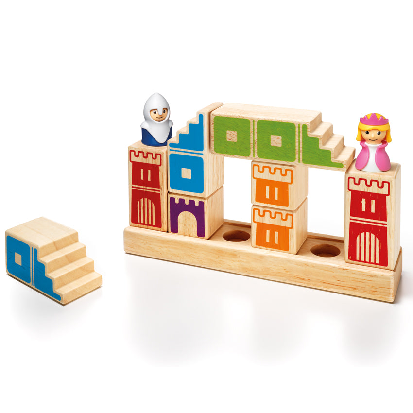 Camelot Junior game in play. A knight and princess piece are standing on top of several wood block pieces with castle walls painted on them in different colors. There is a long, rectangle, wooden base that the pieces sit on. Off to the left is one wooden block with blue colored shaped painted on it, and steps cut into one side . 2 additional pieces in play also have steps cut into one side.