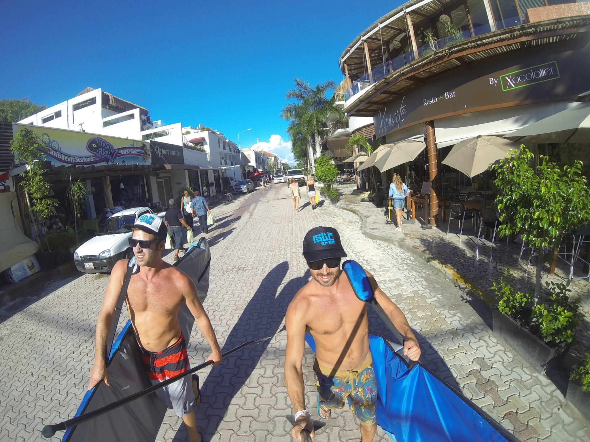 isle riders dirk and marc carry their isle paddle boards through the streets of playa del carmen