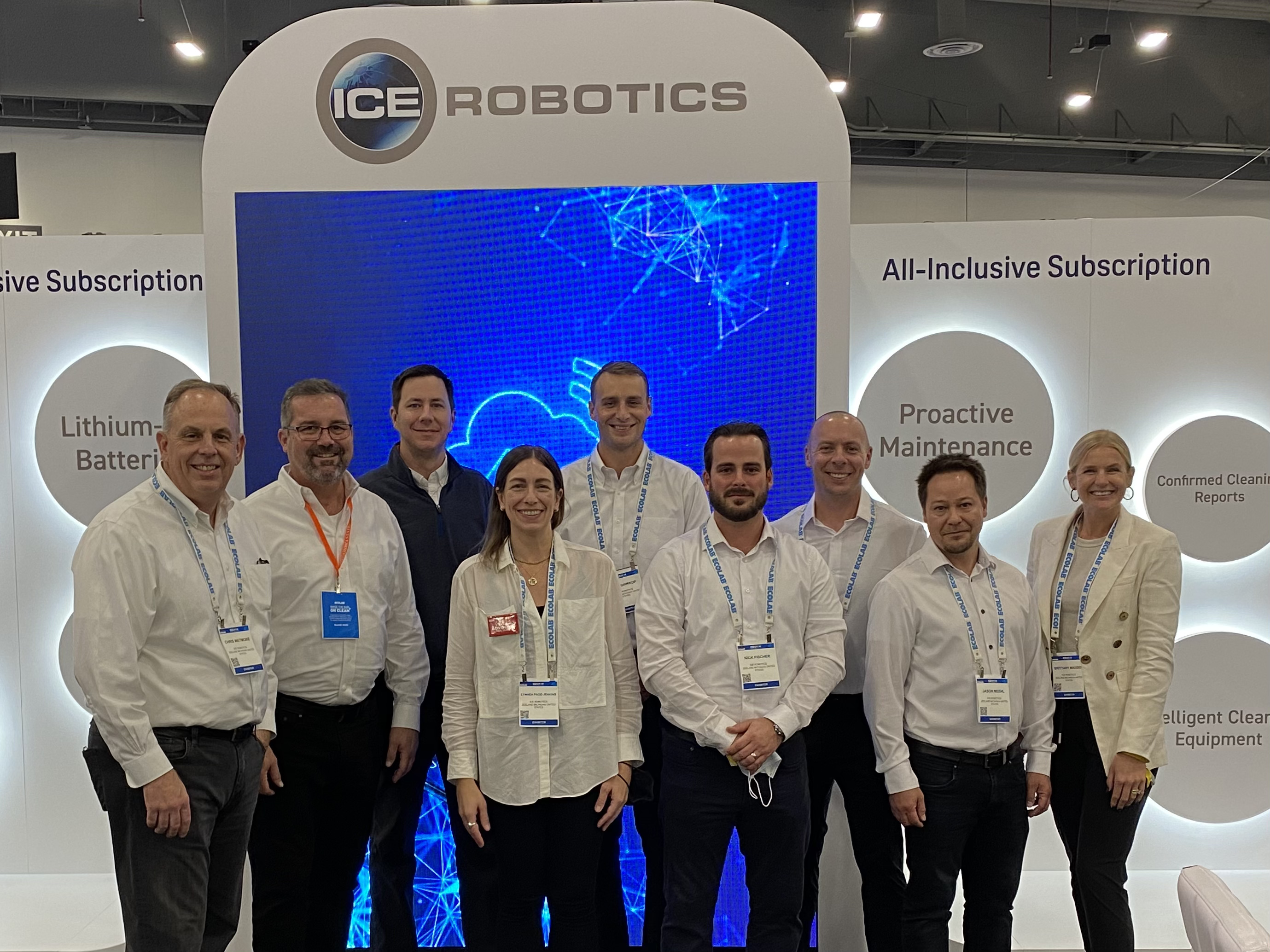 picture of the the ICE Cobotics booth team standing in front of tall blue screen