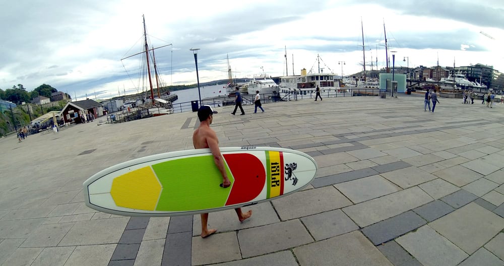 Dirk walking around a pier in Oslo Norway with a pasta inspired isle paddle board