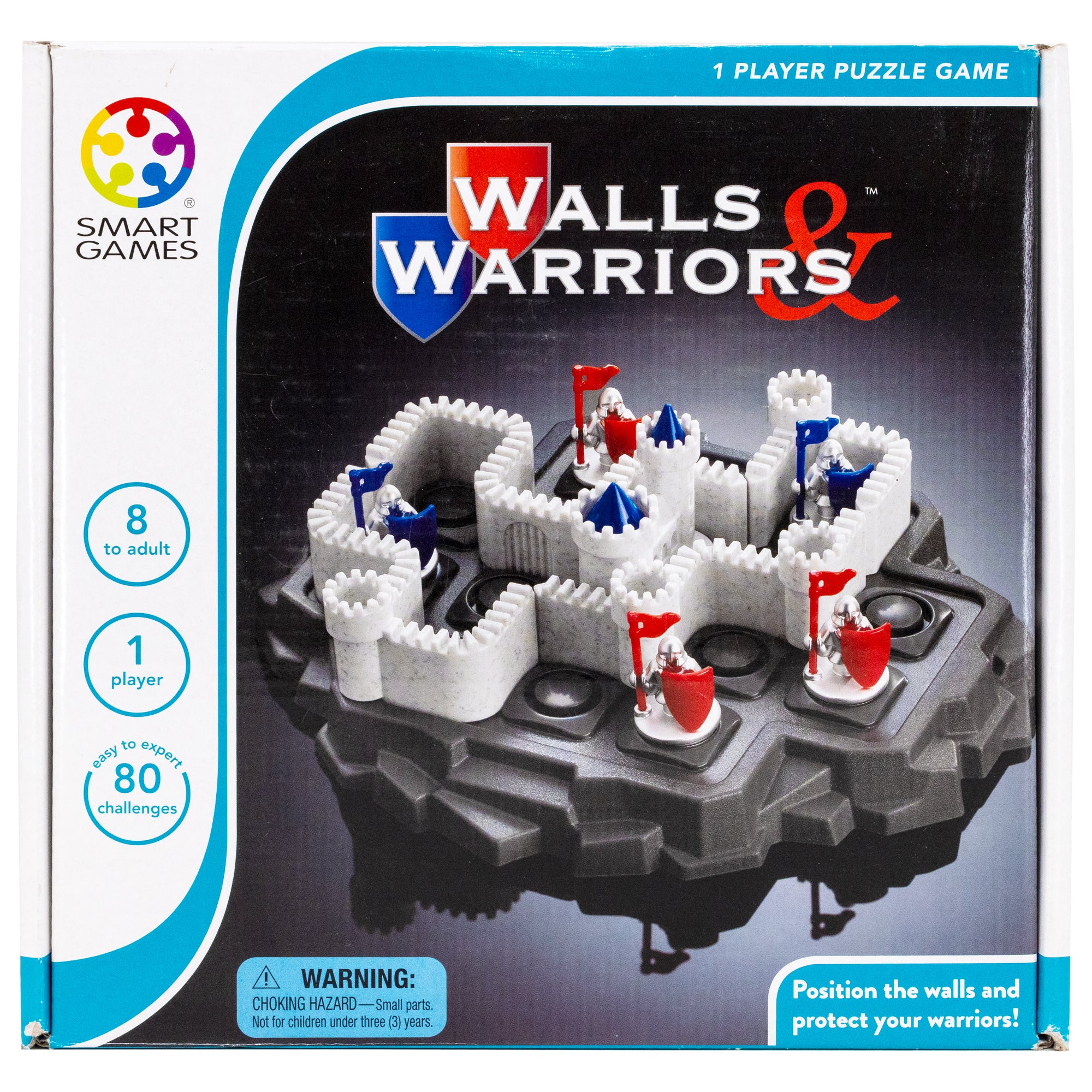Walls & Warriors game box showing the game in play on the cover. The game base looks like a gray rock island with circles cut into squares on the top, allowing game pieces to be put in place. There are castle wall pieces and silver knight pieces with red and blue flags and shields. There are 4 castle wall pieces, 2 blue knights, and 3 red knight pieces on the board. The box indicated that it is a 1 player game for ages 8 and up. Text in the bottom-right reads “position the walls and protect your warriors.”