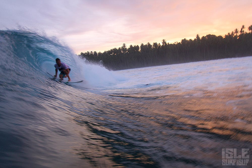 isle rider dirk gets barreled as the sun sets in the horizon