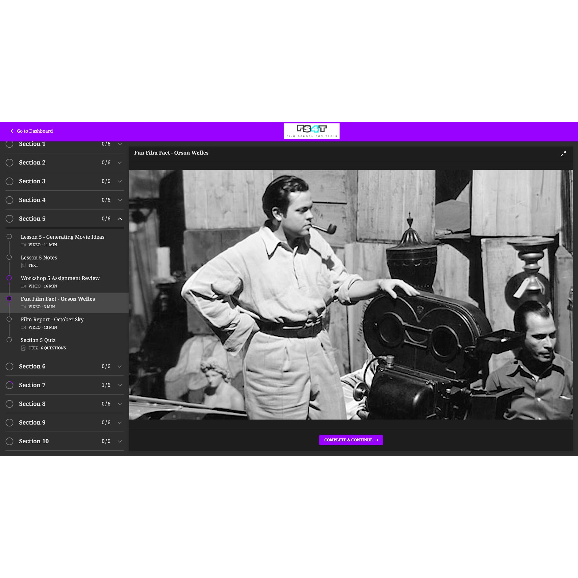 A screenshot of the Intro to Filmmaking program. There is a menu on the left and the background is a dark gray and black with a bright purple top and button at the bottom. The middle of the screen shows a video shot of an old black and white film crew in the middle of filming a movie. The director is standing with his left hand propped up on top of a large film camera while smoking a pipe. In the background is a sitting man, stacked large wood crates, a stone woman statue, a lamp, and a candle.