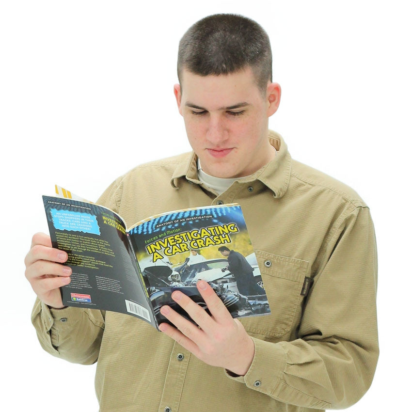 A teenage boy is standing and reading the Forces and Motion: Investigating a Car Crash book. The book cover shows a car accident involving 4 vehicles. There is a man in the background looking at one of the vehicles and a man in the front with a large camera, getting ready to take pictures. The top of the page has a stripe and dot pattern that lead down to the yellow book title. The back cover is black with yellow text.