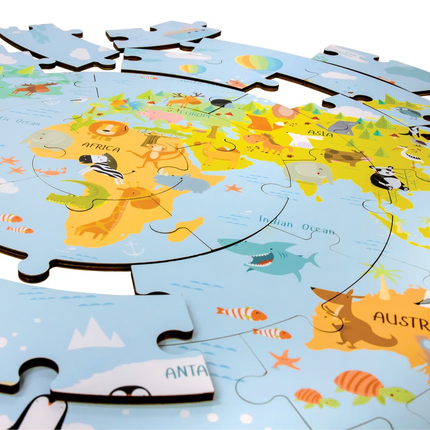 A close up of the Wooden World Map Puzzle mostly put together with several pieces off to the side. The puzzle is circle shaped and the picture is of the globe with illustrations of animals represented by their country.