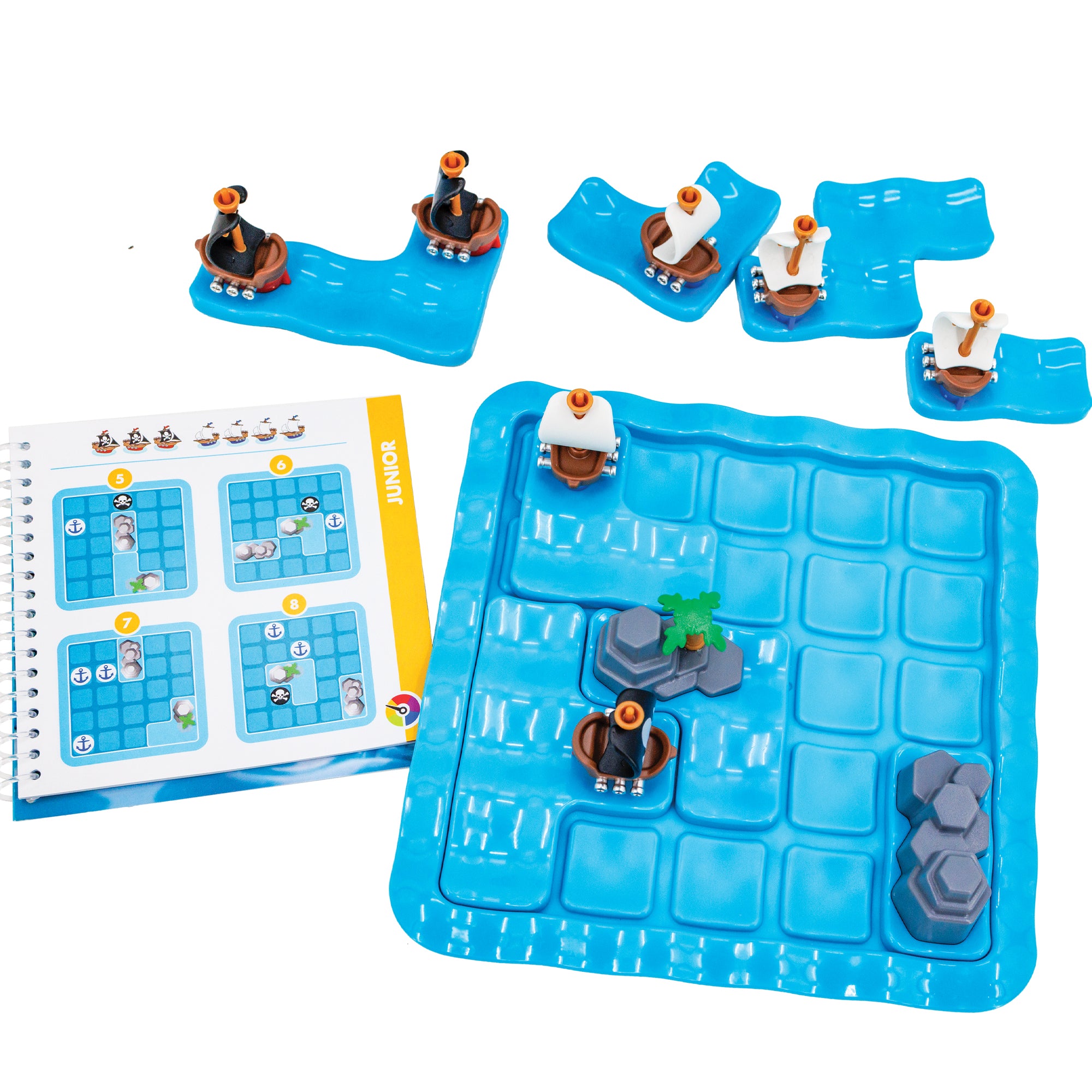 Pirates Crossfire game. The gameboard is blue and wavy in a square shape with rounded corners. There are 4 pieces set in place on the board; one white-sailed ship, one black-sailed ship, and 2 rock pieces. There are 4 ship pieces off the board to the top. On the left is the instruction booklet open to a junior puzzle.