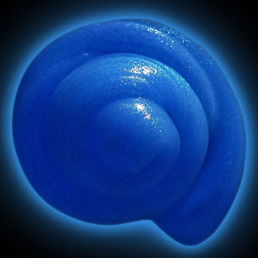 Mixed by Me, Glow, Thinking Putty. The shiny blue, glittered, putty is swirled like a snail shell. The background is black with a blue glow coming from the putty, showing that it is glowing in the dark.