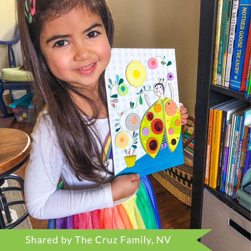 A customer photo of a dark-haired girl in a white dress with a rainbow bottom holding a Djeco So Pop Collages project.  The completed project has a large ladybug in the bottom-right and a planter to the left with long vines coming out and over the top of the page. There are many colored dots glued onto the project.