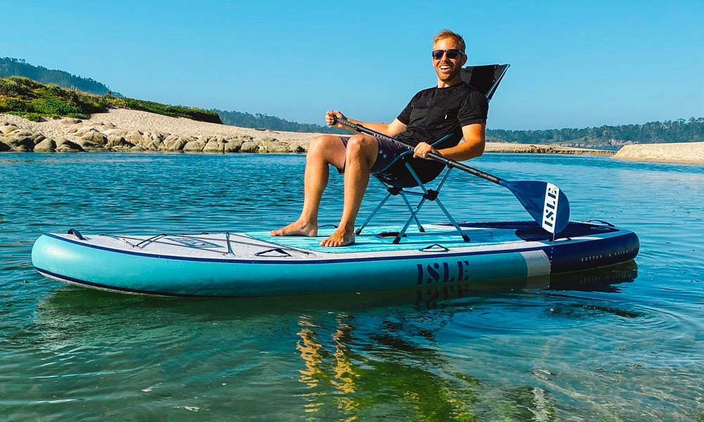 man sitting on chair on large paddle board