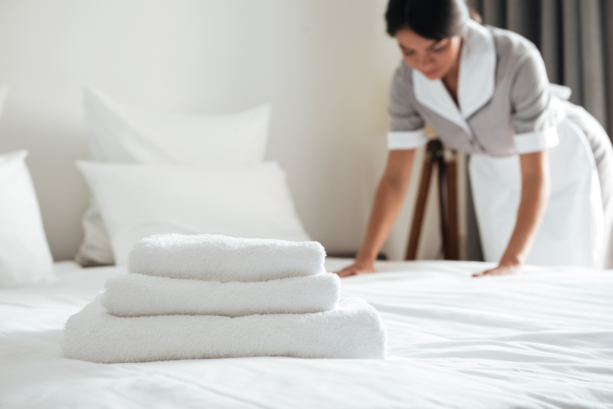 Housekeeping making a bed in a hotel
