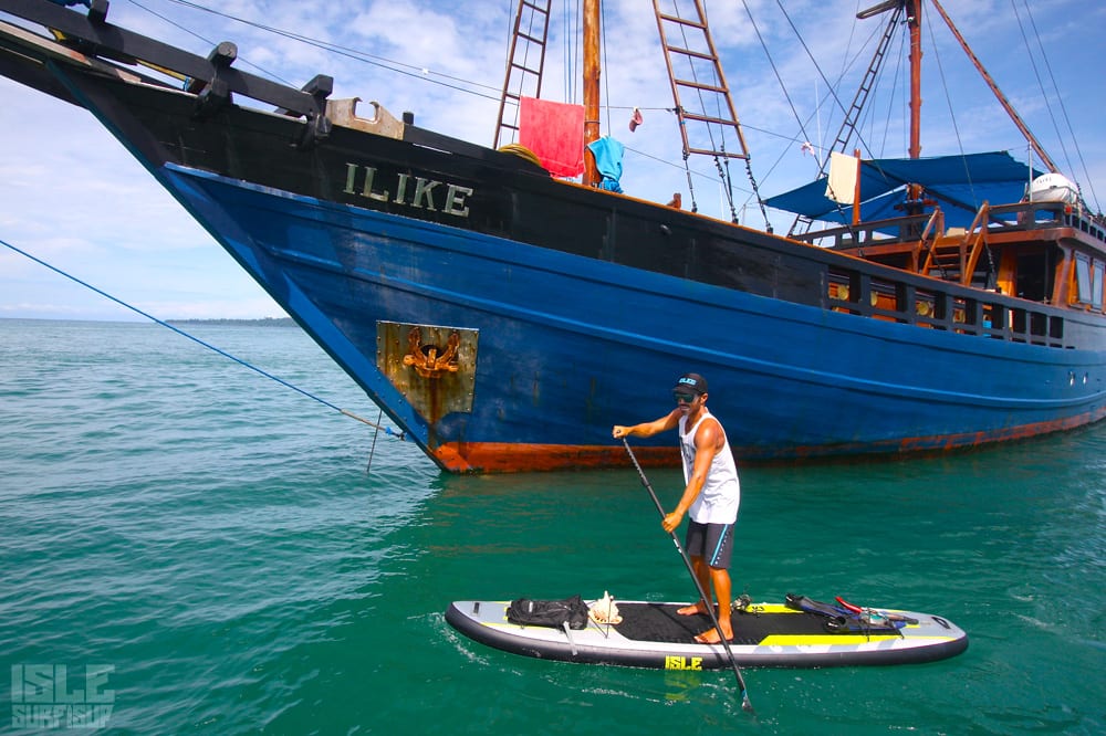 marc paddling around the his floating home boat Ilike on an isup  in indonesia