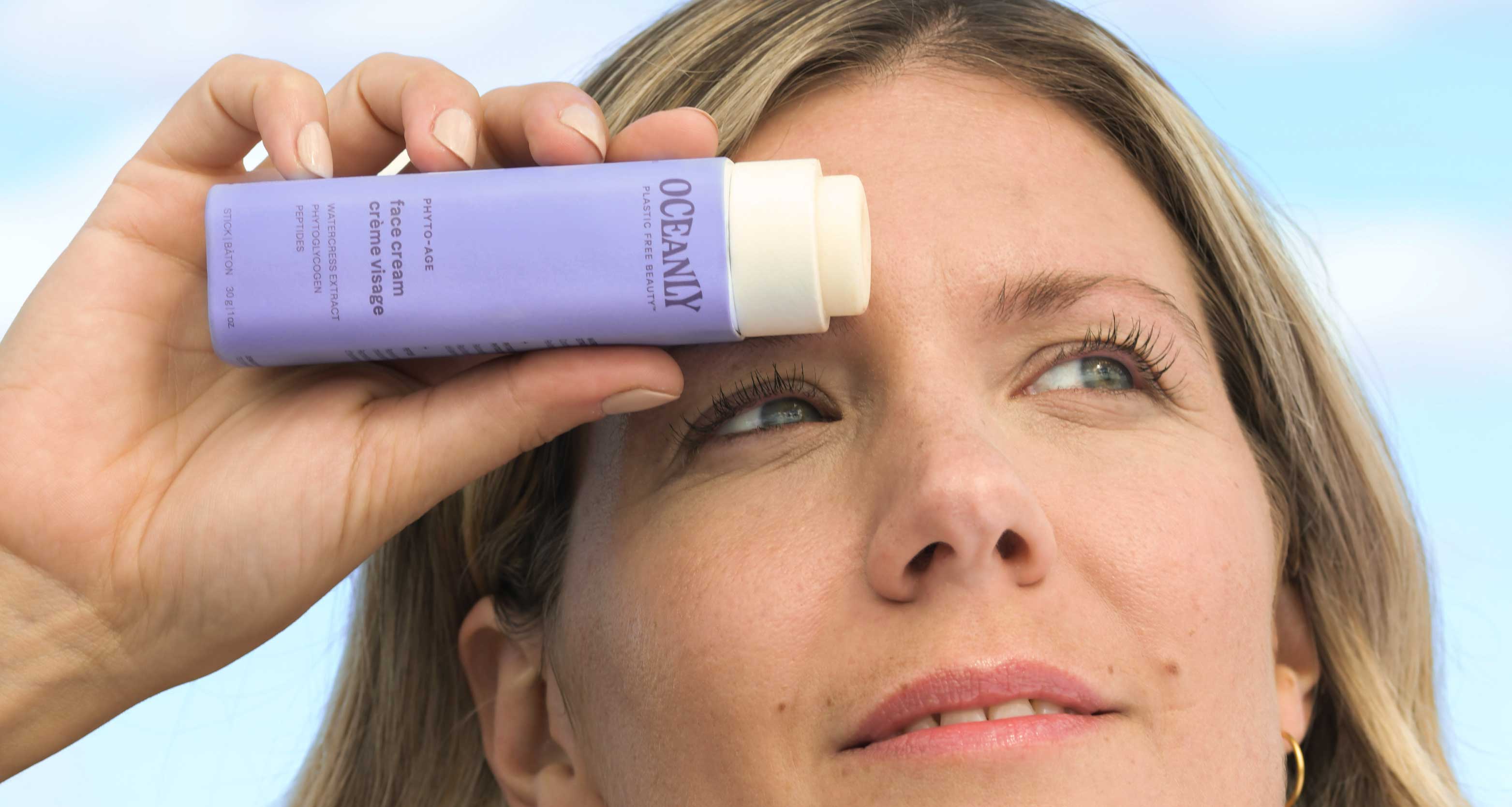Woman hanging a Phyto-Age face care product for her anti-aging skincare routine.