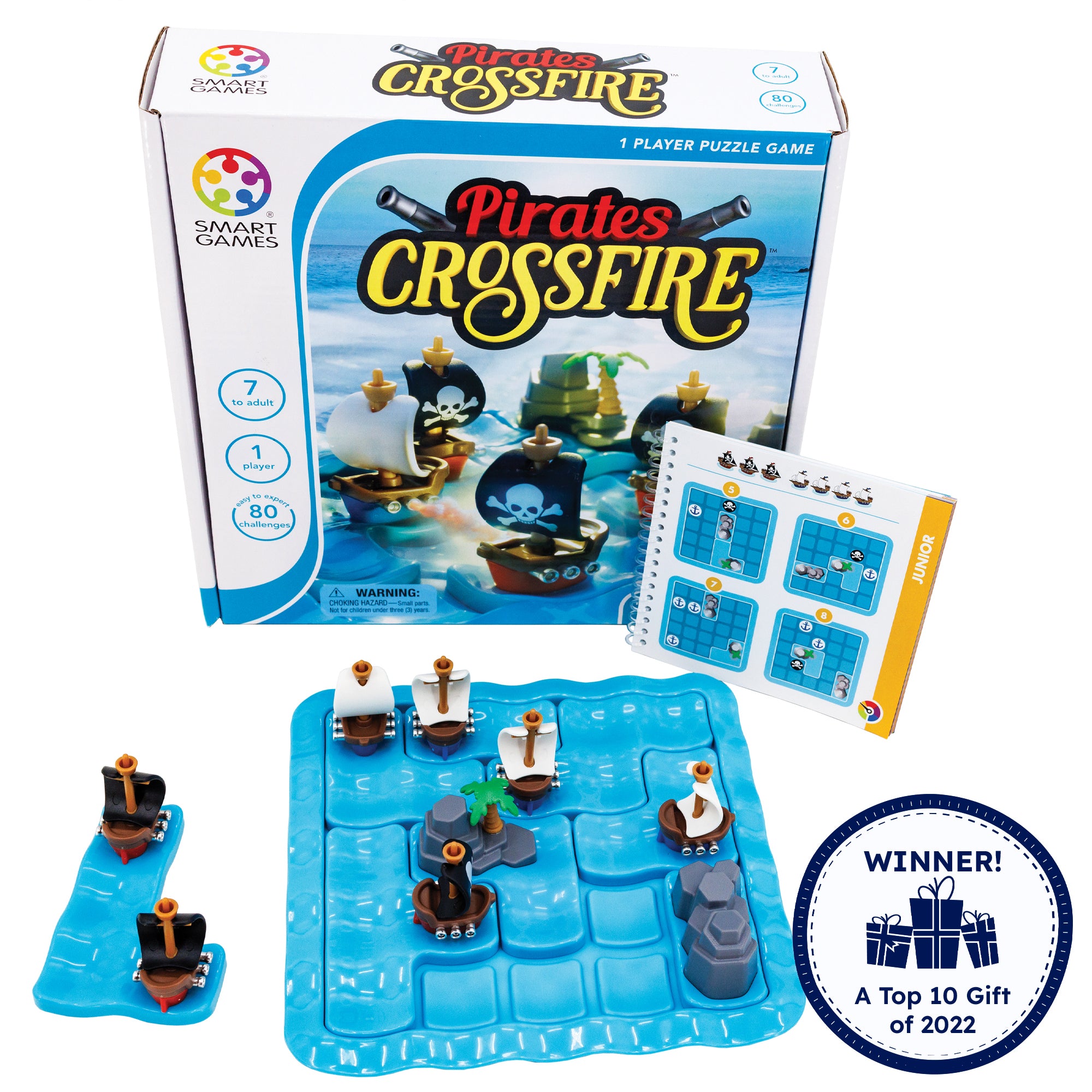 Pirates Crossfire game. The gameboard is blue and wavy in a square shape with rounded corners. There are 4 pieces set in place on the board; one white-sailed ship, one black-sailed ship, and 2 rock pieces. There are 4 ship pieces off the board to the top. On the left is the instruction booklet open to a junior puzzle. The game box in the background shows the game with pieces in play. In the bottom left is a badge reading “Winner! A top 10 gift of 2022.”