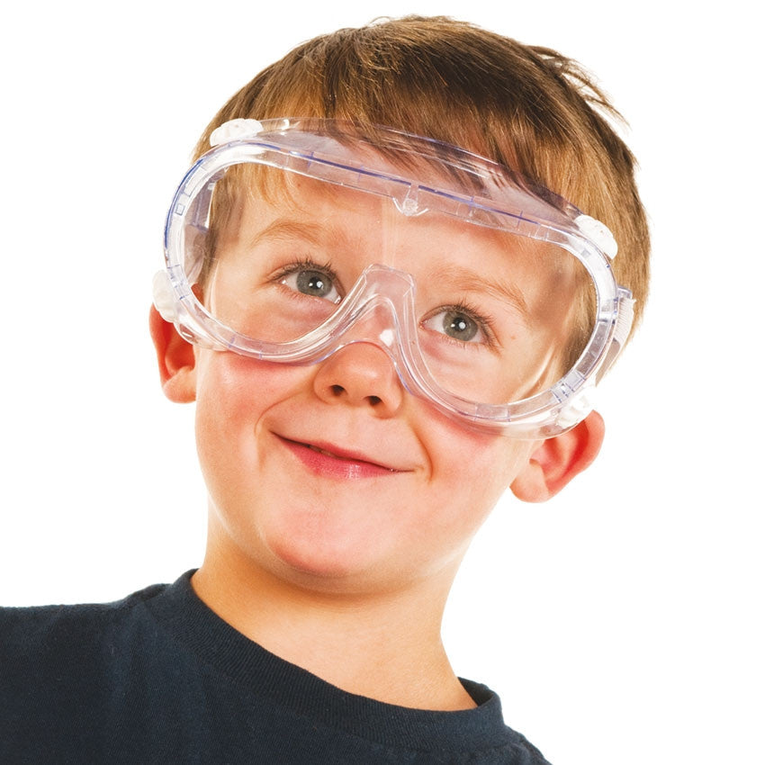 Boy with dark blonde hair wearing safety googles, smiling and looking up.