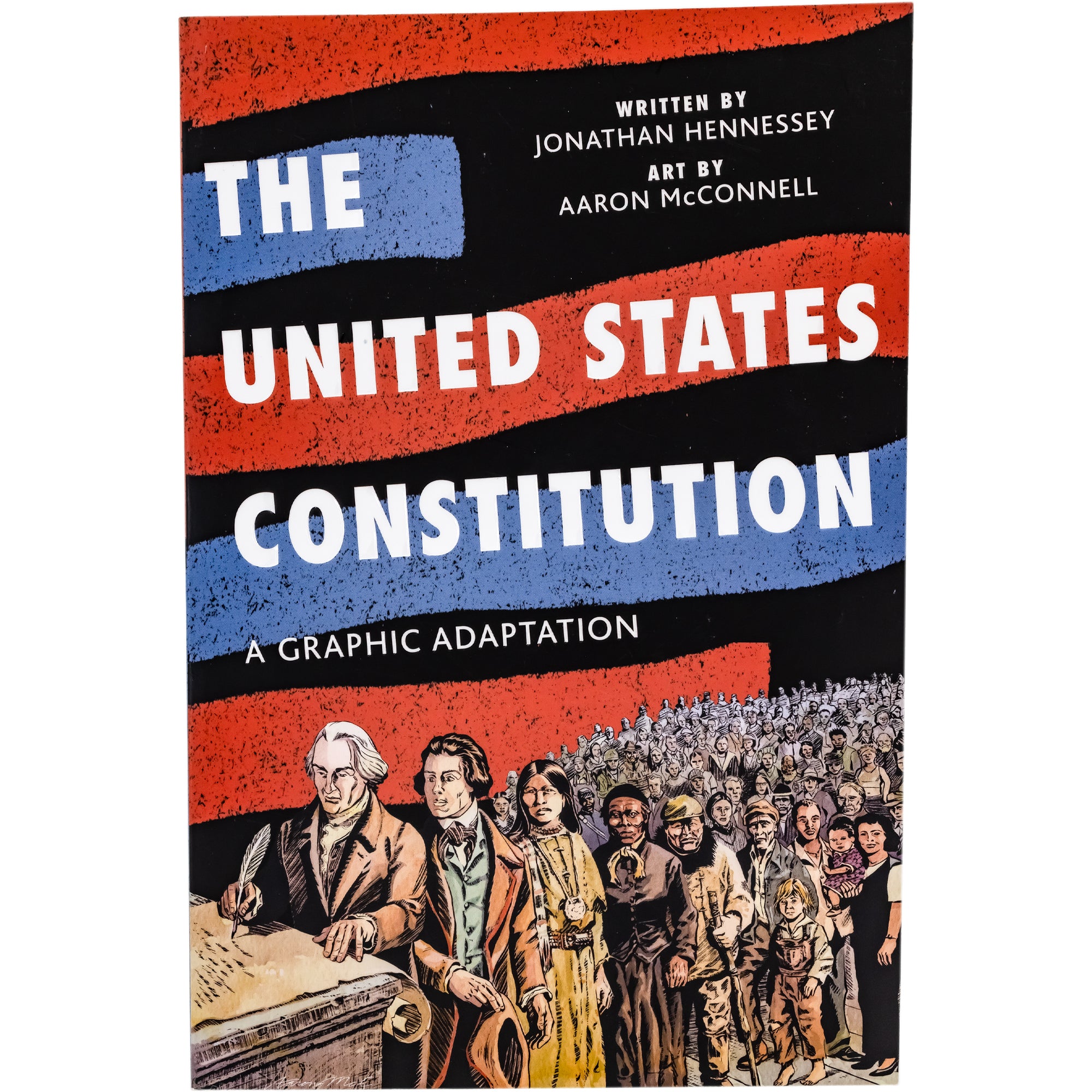 The United States Constitution book cover. The background is black with large red and blue highlights across the page. The title text is written in white across the top and middle. The bottom has an illustration of a man signing the constitution with a large crowd lined up behind him. The crowd includes men, women, and children of different ethnicities.